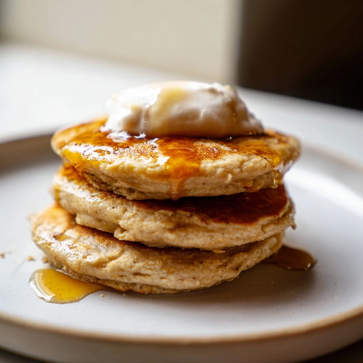 Golden-brown, fluffy protein banana pancakes stacked high, ready to be topped and devoured.