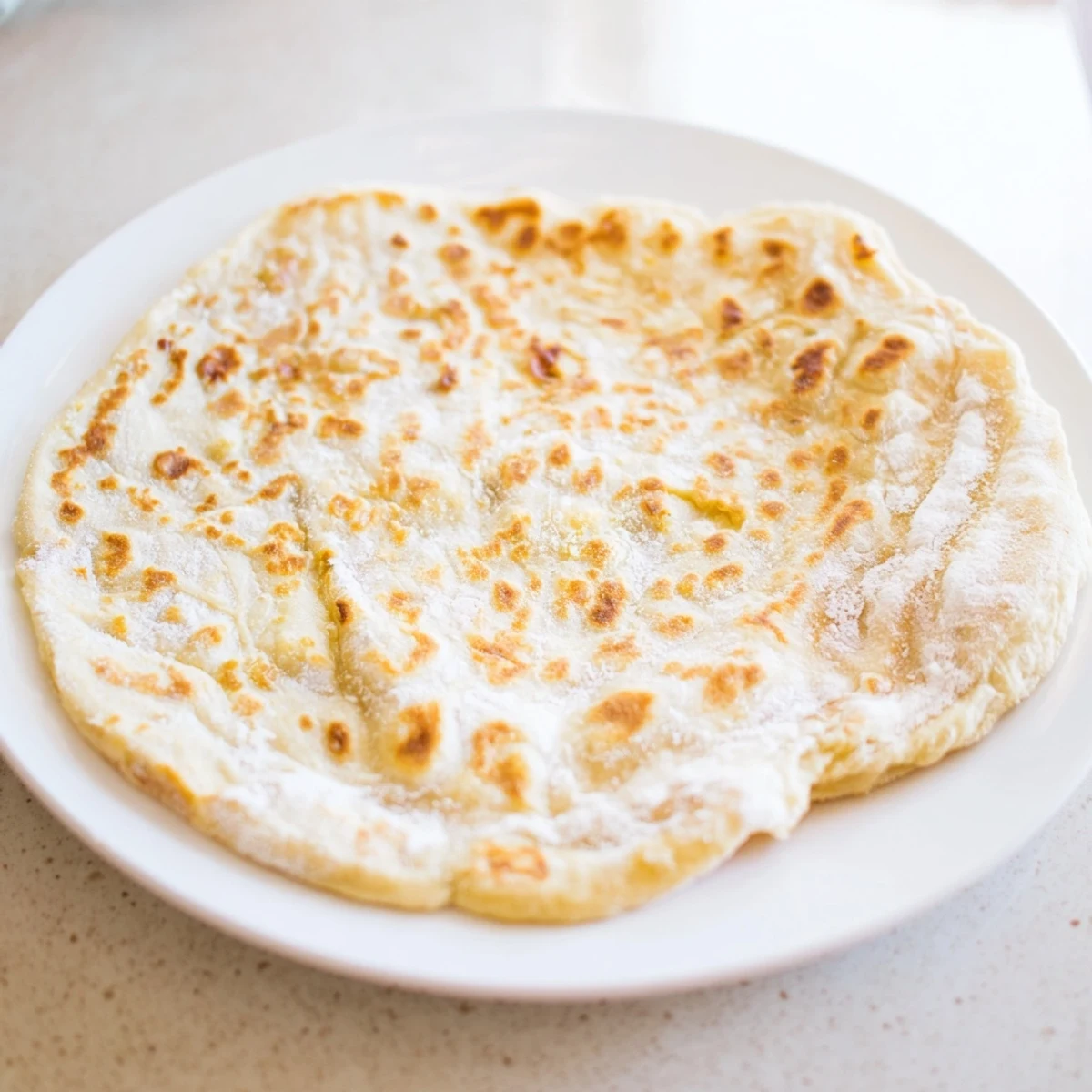 Golden-brown cottage cheese flatbread, pan-fried to perfection, ready to be served warm.