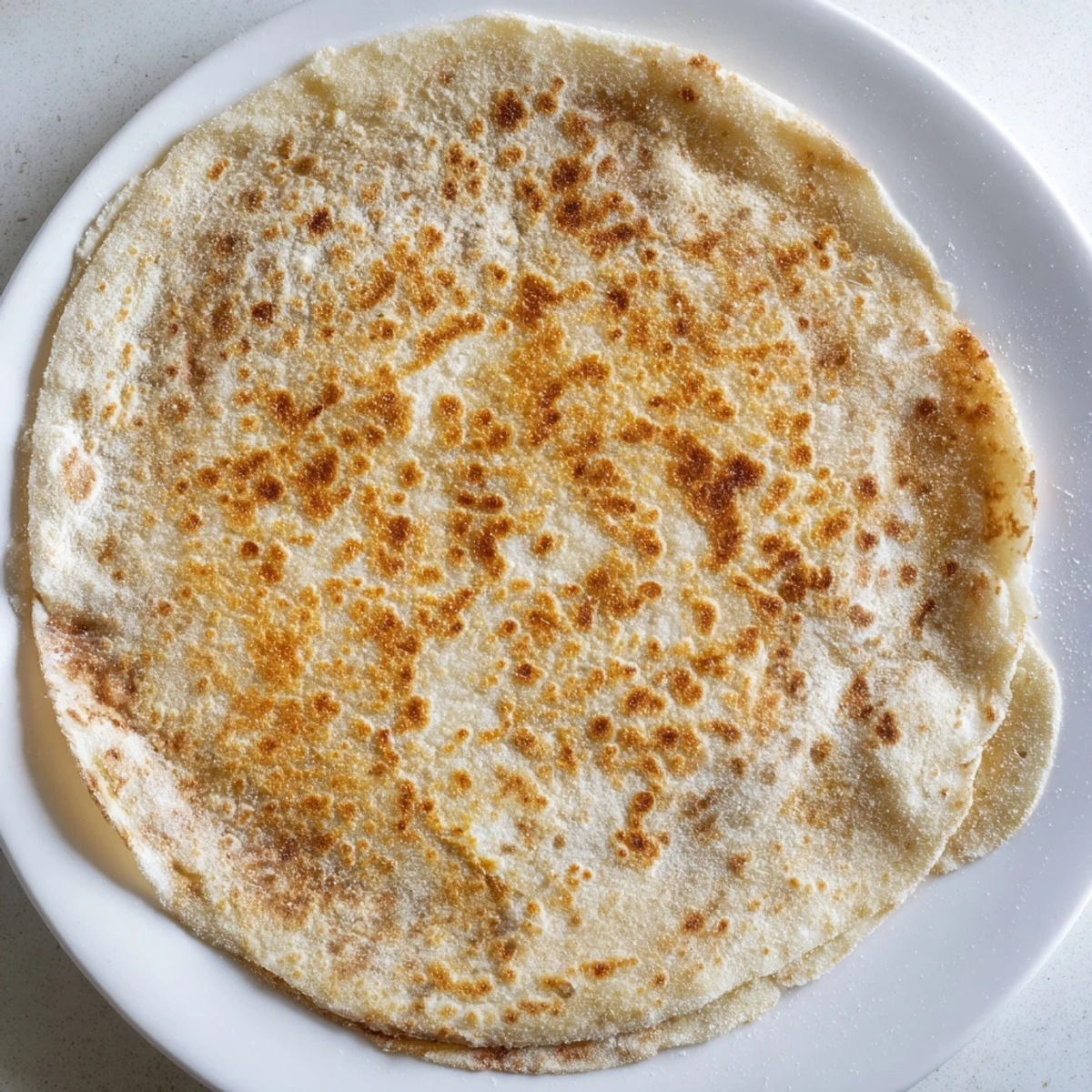 Close-up of rustic cottage cheese flatbread, showing a soft interior and golden-brown crust.