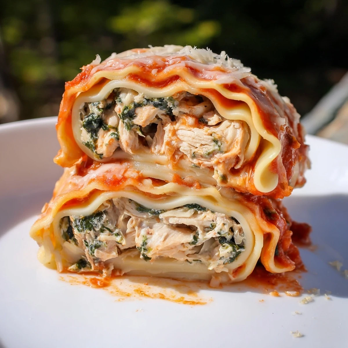 Golden-brown Chicken and Spinach Lasagna Rolls filled with creamy ricotta and spinach, bubbling under melted mozzarella in a rich marinara sauce.  