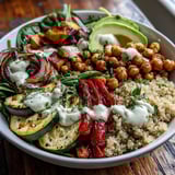 A colorful vegan Roasted Chickpea Power Bowl with golden chickpeas, sweet potatoes, and avocado over greens, finished with a luscious tahini drizzle.