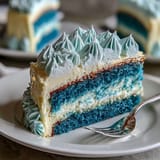 Three-layer ombre cake in deep blue shades, frosted with rich vanilla buttercream and finished with shimmering gold leaf for a festive look.