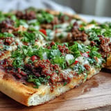 Savory ground lamb toppings on thin Turkish Lahmacun flatbread, hot from oven.