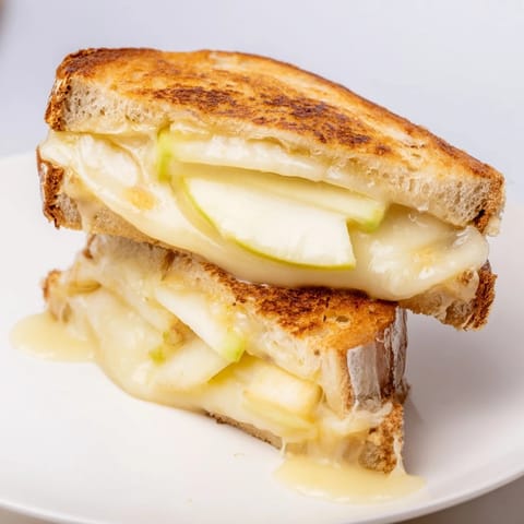 Buttery sourdough embracing creamy Brie and apple in a delicious Brie and Apple Grilled Cheese sandwich.