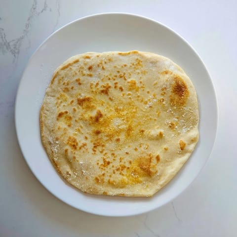 A stack of fluffy, freshly cooked cottage cheese flatbread, perfect for dipping or wraps.