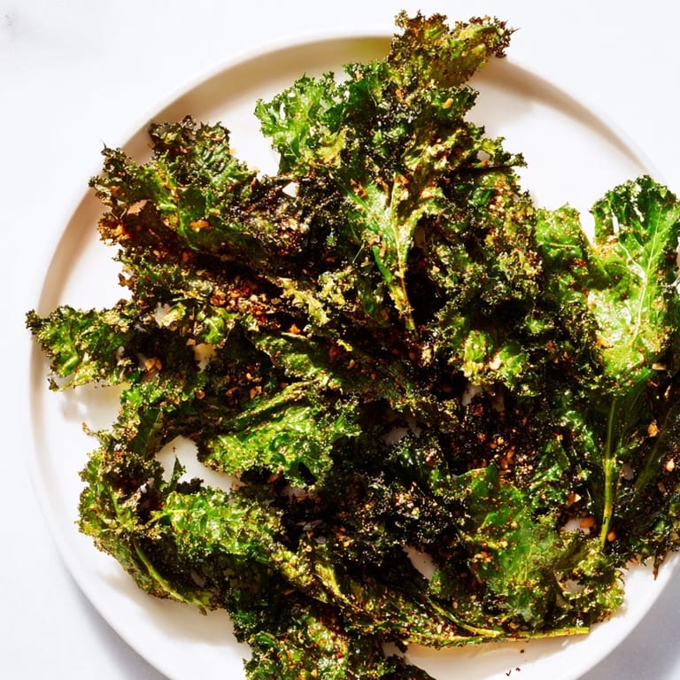 Savory and flavorful: a plate of oven-baked kale chips ready to enjoy as a light, vegan snack.