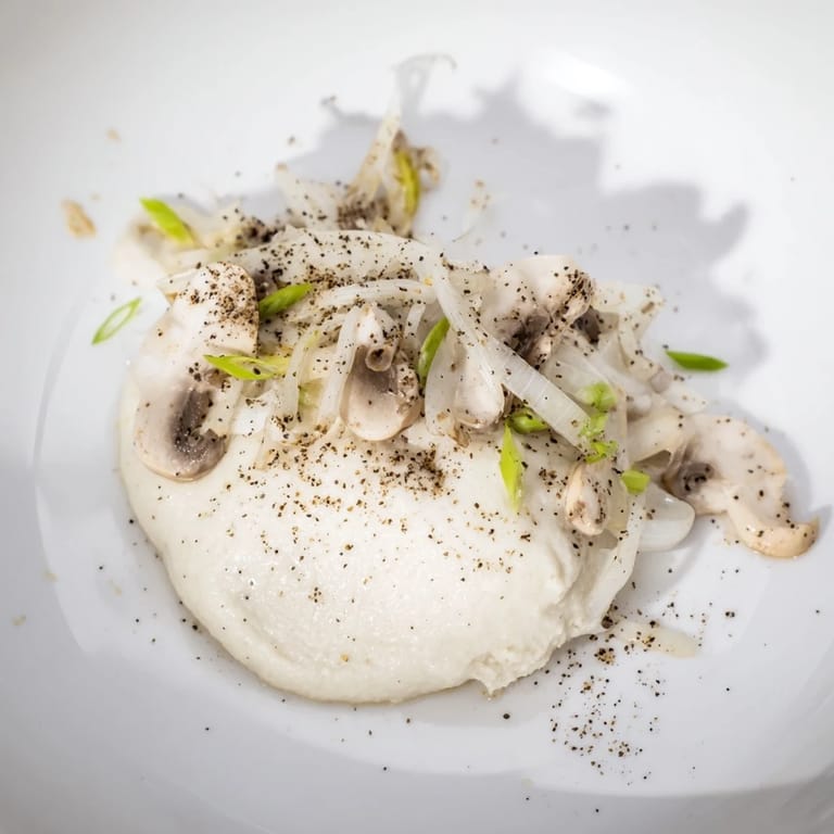 A stunning plate of The Ghostly Gala, featuring tender chicken with a creamy cauliflower base, a savory dish.