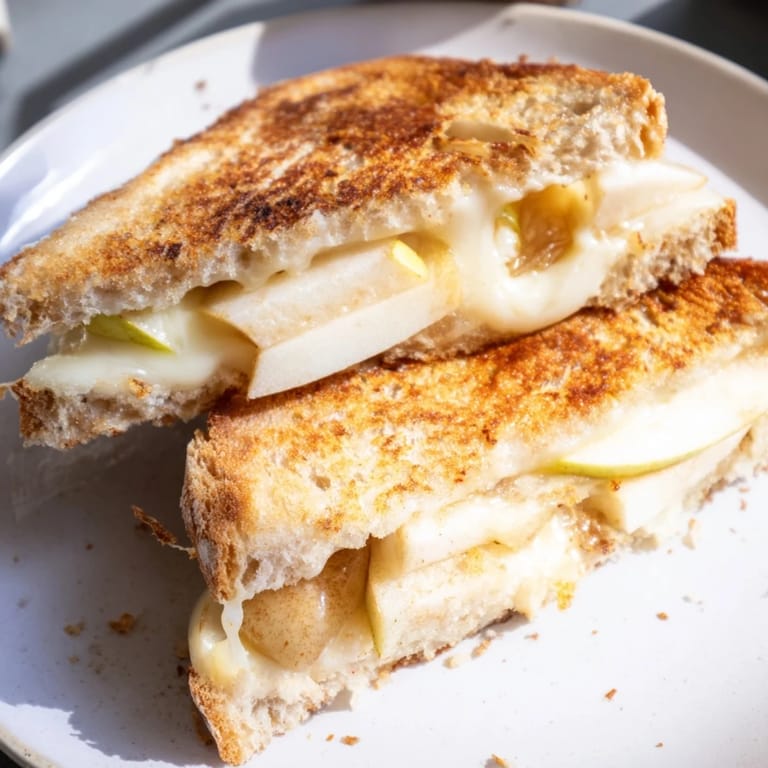 Melted Brie and apple slices oozing between golden sourdough in this gourmet Brie and Apple Grilled Cheese.