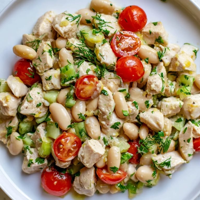 A colorful bowl of Lemony White Bean Chicken Salad featuring tender chicken, white beans, cherry tomatoes, and fresh dill, ready for a light lunch or picnic.